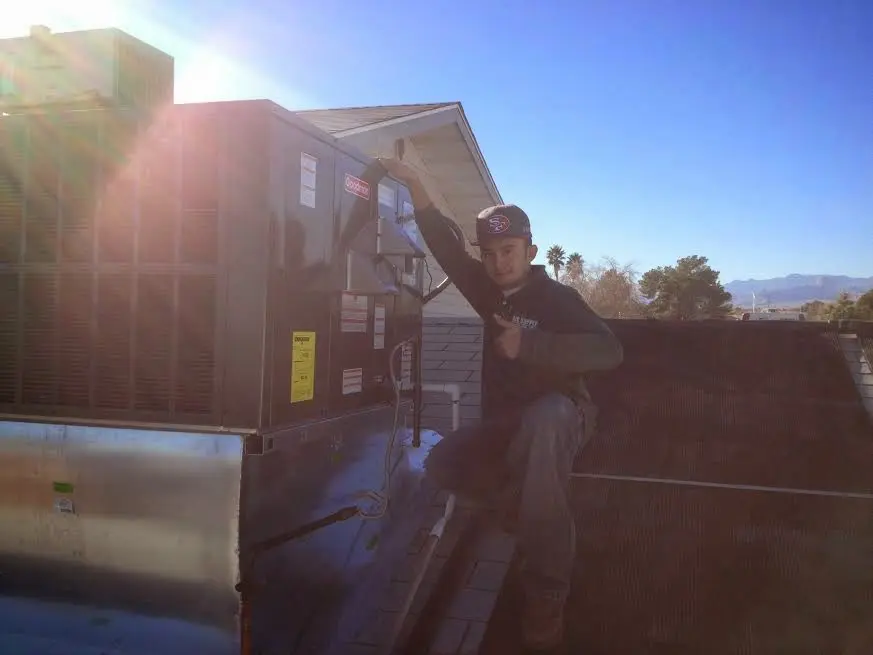 HVAC technician performing AC Tune-Up on a rooftop unit in Solvang